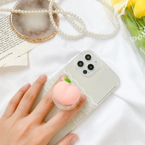 Gros plan d'un support de téléphone mignon en silicone rose en forme de pêche avec décor