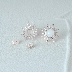 Macro detail of S925 sterling silver opal stud earrings with sunburst halo design