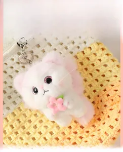 Close-up of cute plush angel cat keychain with pink flower and metal lobster clasp detail