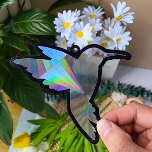 Close-up of holographic hummingbird suncatcher creating rainbow prism light reflections