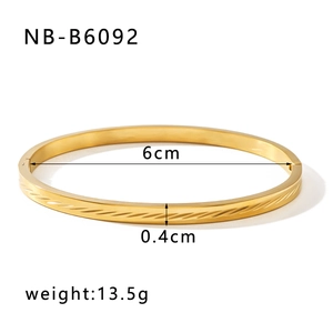 Vista macro di un bracciale in acciaio dorato con texture irregolare e dimensioni