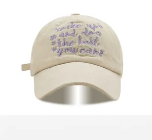Detail of beige cotton baseball cap featuring purple embroidered motivational text