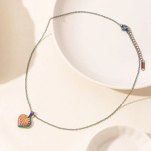 Detailed close-up of rainbow heart pendant with honeycomb texture and lobster clasp