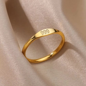 Macro shot of gold-plated stainless steel ring with 999 engraving on satin