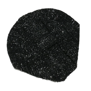 Dettaglio del berretto in maglia con paillettes nere e design a pieghe incrociate