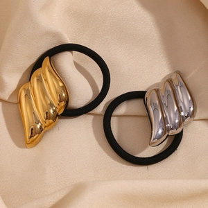 Minimalist 18K gold and silver plated wing-shaped metal hair ties on beige silk fabric