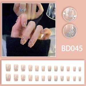 Macro detail of nude pink press-on nails with silver glitter lines and pearl accents