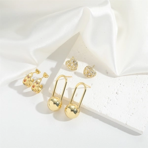 Three-pair gold earring set featuring heart studs, U-shaped drops, and small crystal hoops