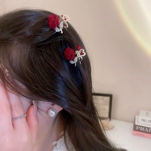 Detail view of mini red flocked rose hair clips with rhinestone leaves on model