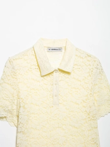 Detail of light yellow lace polo shirt collar with buttons and size M inner brand label