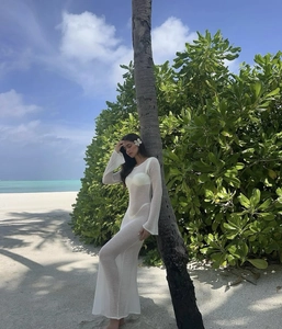 Detail von weißem Strandkleid aus Netzstoff mit offenem Rücken und langen Ärmeln