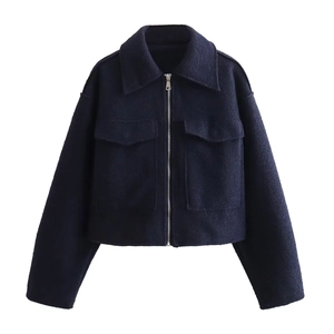 Detail of dark blue cropped tweed jacket with silver zipper and flap chest pockets