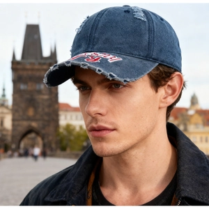 Détail de la casquette de baseball en jean bleu marine avec broderie vintage vieillie