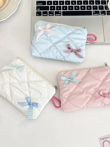 Quilted ribbon bow cosmetic bag in light blue, white, and pink with glossy finish