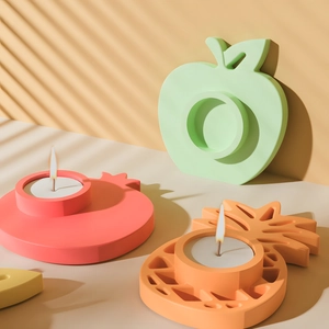 Detail showing creative fruit-shaped candle holders with lit tea wax in warm light