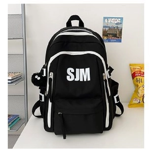 Detail view of large capacity black and white backpack with plush monster keychain charm