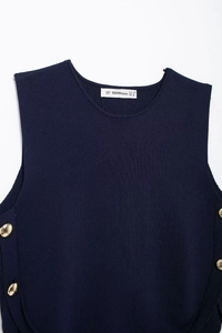 Close-up of navy knit vest neckline with gold buttons and brand size label detail