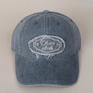 Close-up of vintage washed blue cotton baseball cap with embroidered patch and stitching