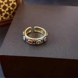 Macro detail of vintage gold open ring with colorful gemstones and geometric reliefs