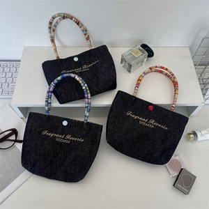 Detailed view of mini denim lunch bags with colorful beaded handles and gold embroidery