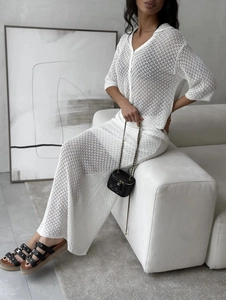 Elegant white knit two-piece set featuring hollow crochet cardigan and matching maxi skirt