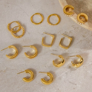 Gros plan détaillé de boucles d'oreilles en acier titane doré avec accents diamants