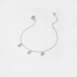 Detail of silver heart charm bracelet with sparkling zircons and delicate link chain