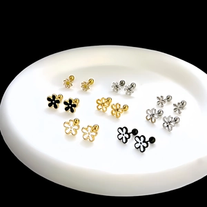 Detailed overhead view of multiple minimalist floral stud earrings in various colors