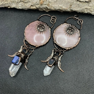 Detail of vintage bronze earrings with pink quartz, sun motif and hanging crystals