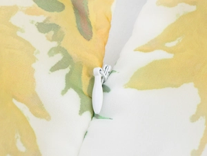 Detailed macro view of the white invisible zipper on sunflower print organza skirt fabric