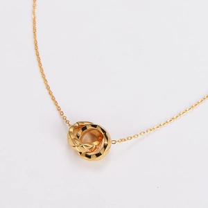 Detailed close-up of three interlocking gold rings with quilted pattern on chain