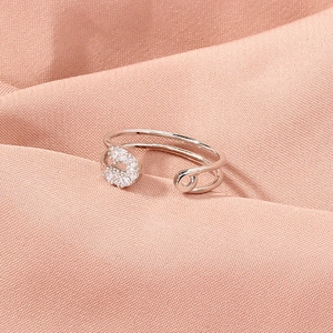 Macro view of silver paperclip ring with micro-pave cubic zirconia on pink fabric