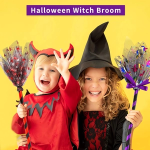 Kids in Halloween costumes holding colorful mesh witch brooms on yellow background