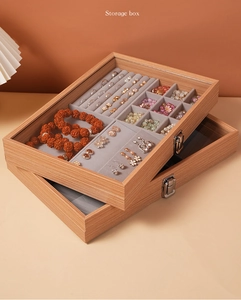 Detail view of walnut wood jewelry box with glass lid, metal lock and velvet interior