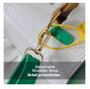 Detail presentation of white crocodile pattern bag with bamboo handle and green strap