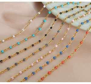 Detailed macro shot of colorful enamel bead gold chains on elegant beige silk fabric