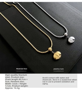 Detailed close-up of gold and silver bean pendants on titanium steel necklaces