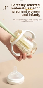 Detail showing a green long-handle cleaning brush scrubbing the inside of a 240ml baby bottle