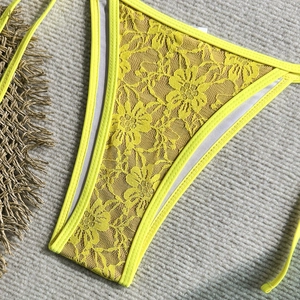 Detailed macro view of yellow floral lace texture and stitching on bikini bottoms