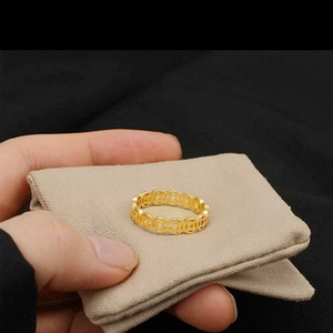 Detailed view of gold-finished ring featuring traditional Chinese coin patterns