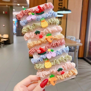 Set of 10 children's hair ties featuring plaid fabric and colorful fruit charms on a card
