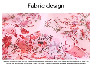 Close-up of pink floral print chiffon fabric with detailed garment washing instructions