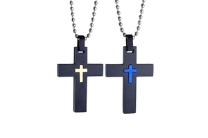 Detail of two black punk style cross pendants with gold and blue metal accents