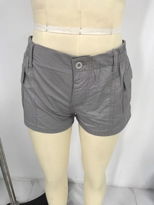 Detail of grey cargo shorts featuring elastic waistband, button fly, and side pockets