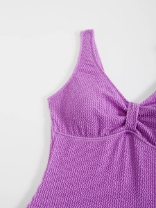 Détail du maillot de bain violet en seersucker avec nœud torsadé et tissu texturé