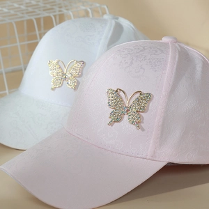 Detailed view of lace baseball caps with crystal-encrusted butterfly embellishments