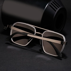Close-up of champagne gold pilot sunglasses with polarized lenses on a black pedestal