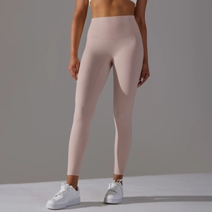Close-up of high-waisted seamless yoga pants in light pink with athletic sneakers