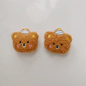 Detailed view of plush teddy bear charms with embroidered faces and party hats