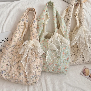 Detailed close-up of floral canvas tote bags with elegant lace bows in various colors